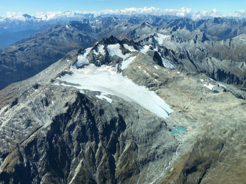 Aerial view of Brewster Glacier, New Zealand, nestled among a rocky mountain range
