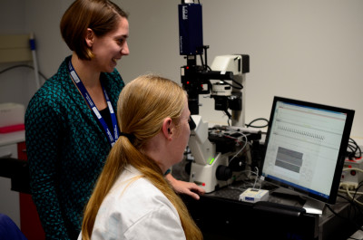 Kim Mellor and a colleague look at data displayed on a screen 