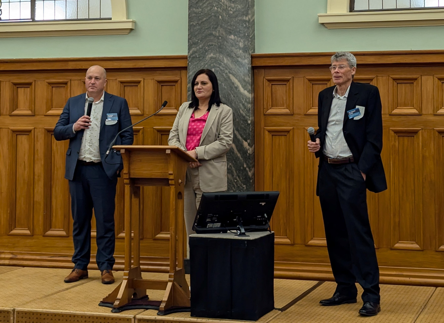 Dr Adam Barker and Dr Graeme Smart with Dr Parmjeet Parmar MP answering questions in the Grand Hall crop Event MC Dr Parmjeet Parmar stands between Dr Barker and Dr Smart as they answer MPs' questions