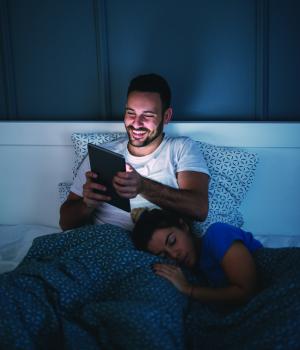 Man reading woman sleeping